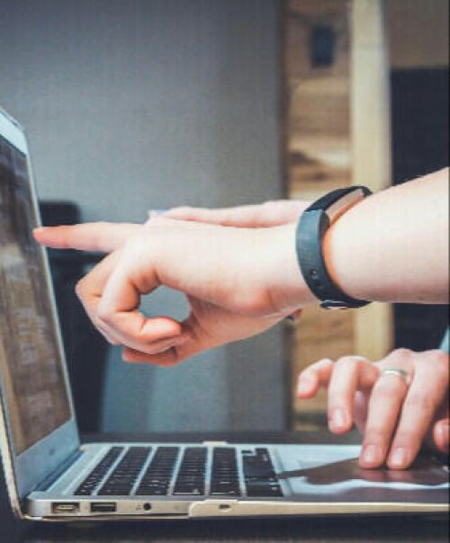 Hand, die mit den Fingern auf ein Laptop-Display zeigt